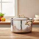 Mauviel M'ELITE B hammered 5-ply stewpan with brass handles and lid, showcasing durable stainless steel cookware.