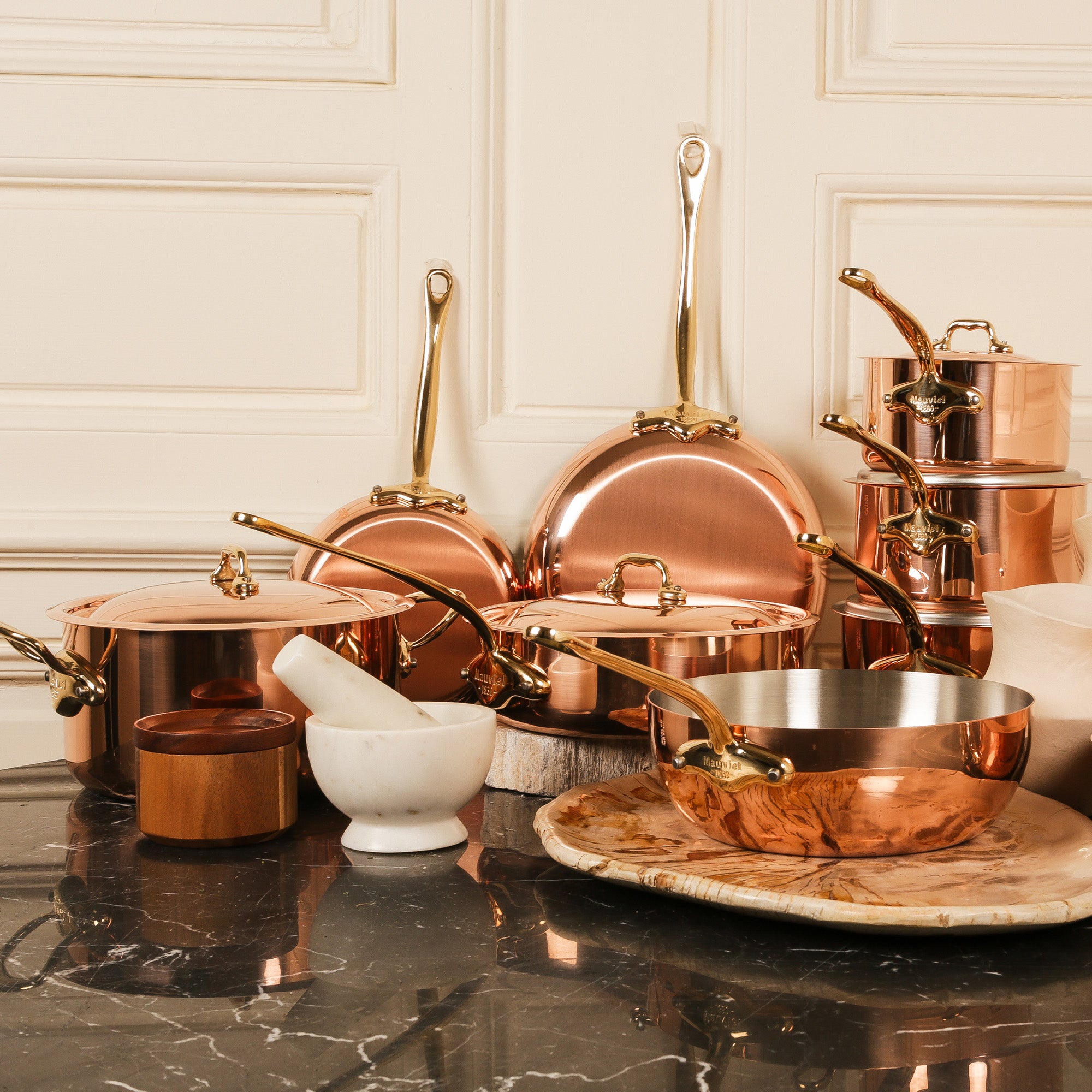 Mauviel M'Heritage M'150 B 2-piece copper oval frying pan set with brass handles, shown on a kitchen countertop.