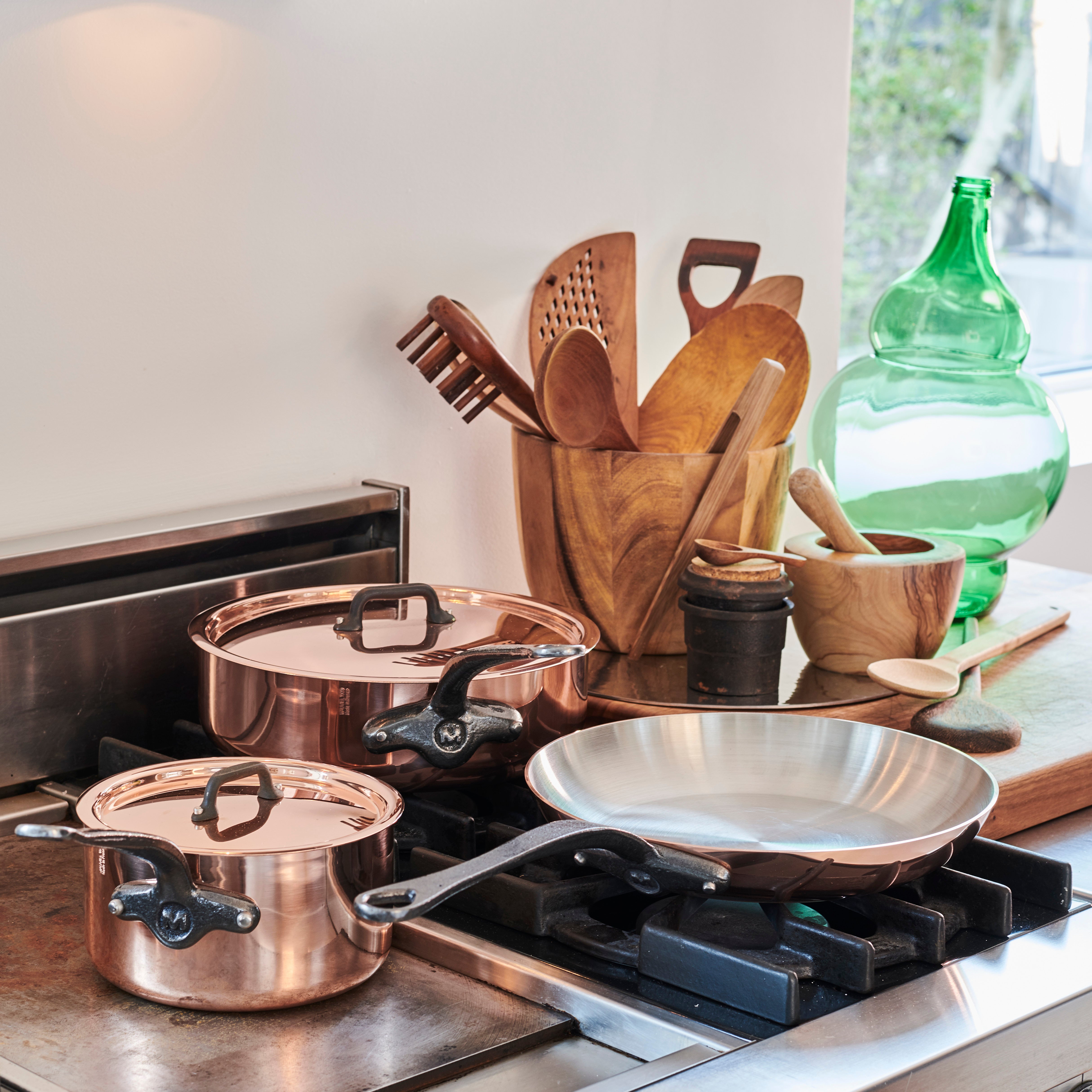 Mauviel M'Heritage M'150 CI copper frying pan set with two pans and cast iron handles, shiny copper cookware for professional cooking.