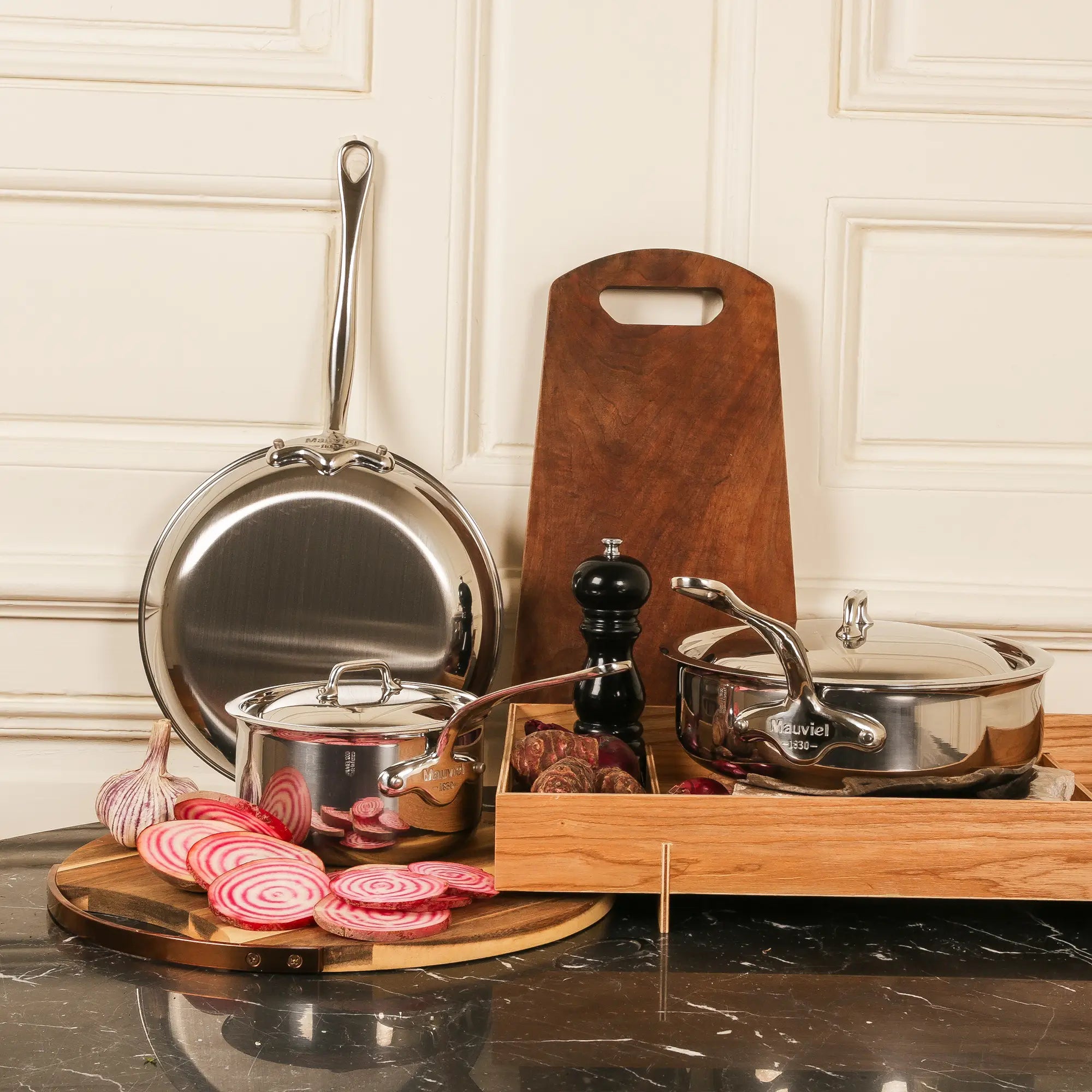 Mauviel M'COOK 5-ply 2-piece frying pan set with stainless steel handles, showcasing shiny, durable cookware on a kitchen surface.