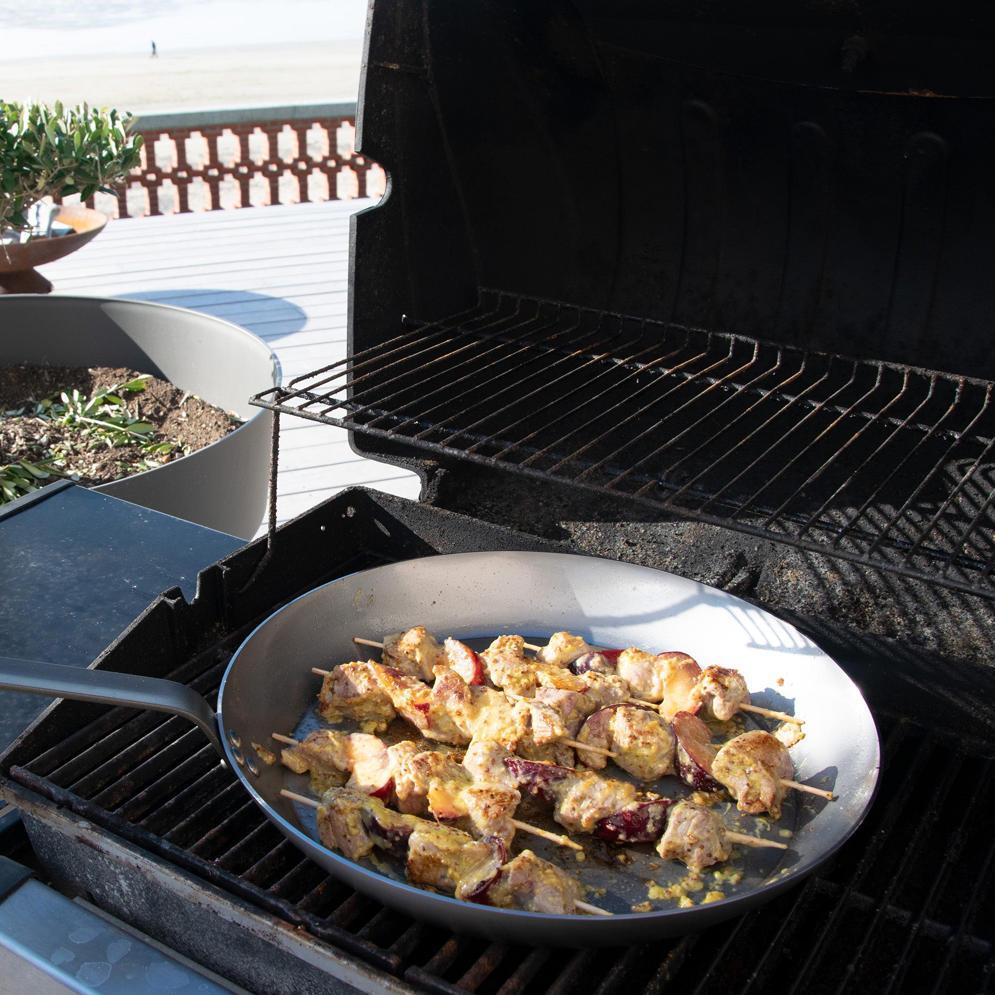 Mauviel M'STEEL black carbon nonstick 3-piece frying pan set with iron handles, displayed on a kitchen countertop.