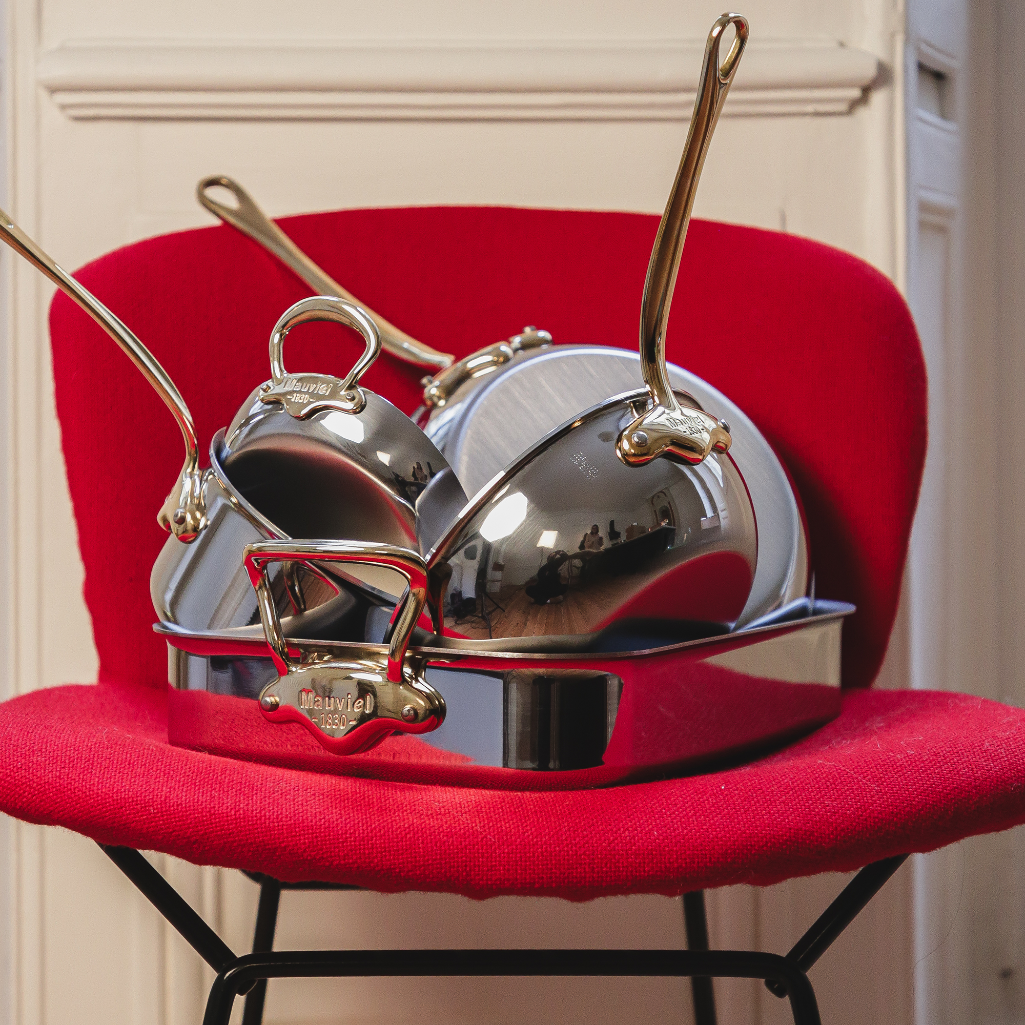 Mauviel M'COOK 5-piece cookware set with brass handles, including pots and pans in polished stainless steel.