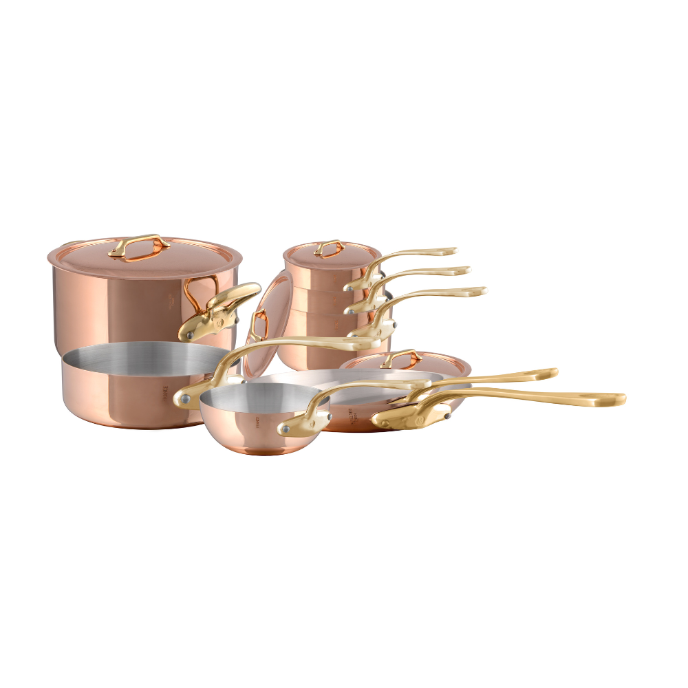 Mauviel M'Heritage M'200 B 12-piece copper cookware set with brass handles, including pots and pans on a kitchen countertop.