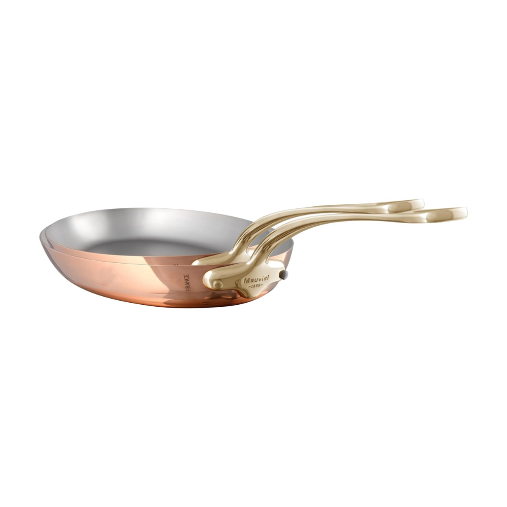 Mauviel M'Heritage M'150 B copper oval frying pan set with brass handles, shown stacked with handles visible and polished copper surface.