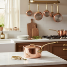 Mauviel M'Heritage M'250 B copper sauce pan with brass handle and lid, showcasing its polished copper exterior and sturdy construction.