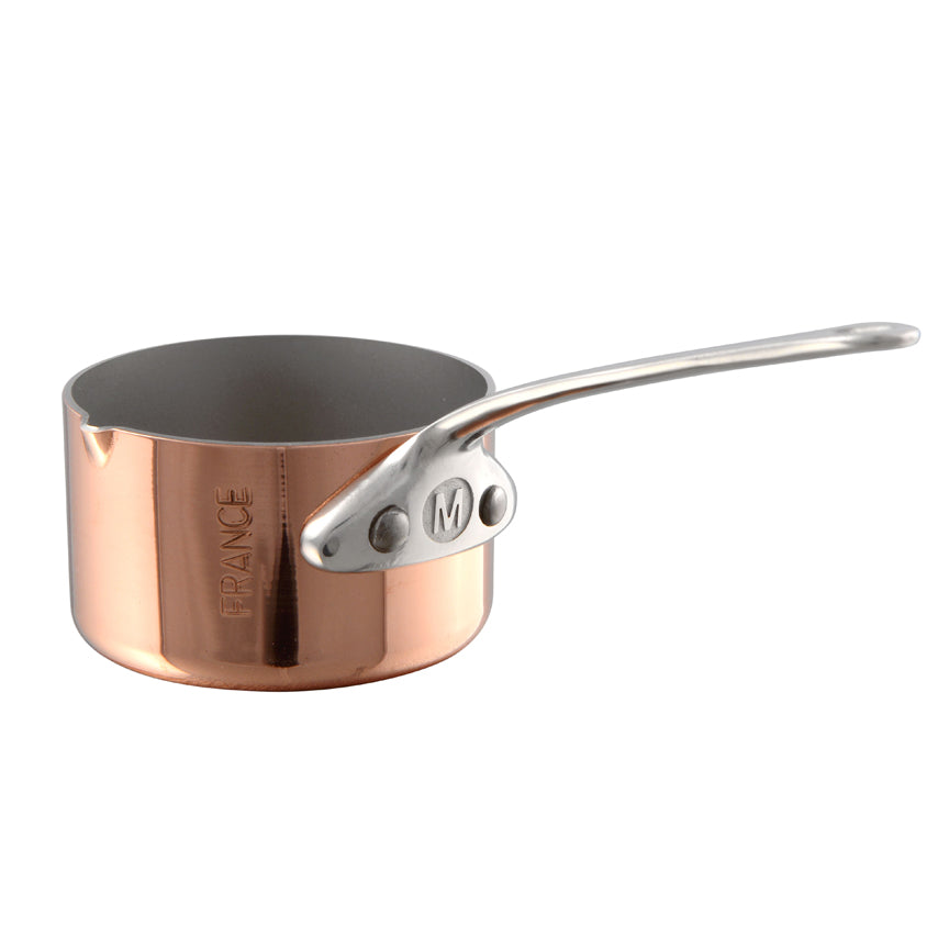 Mauviel M'MINIS copper sauce pan with stainless steel handles and pouring spout, 2-inch size, on a kitchen countertop